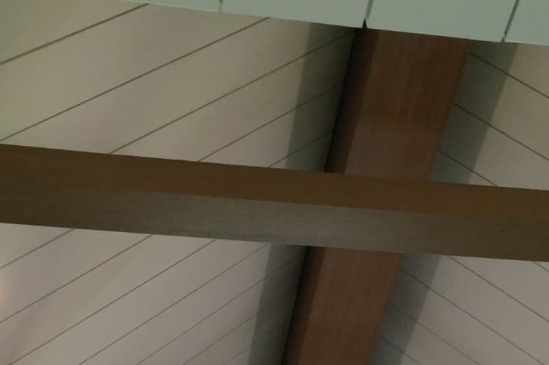 Detail of a white oak ceiling beam meeting the shiplap